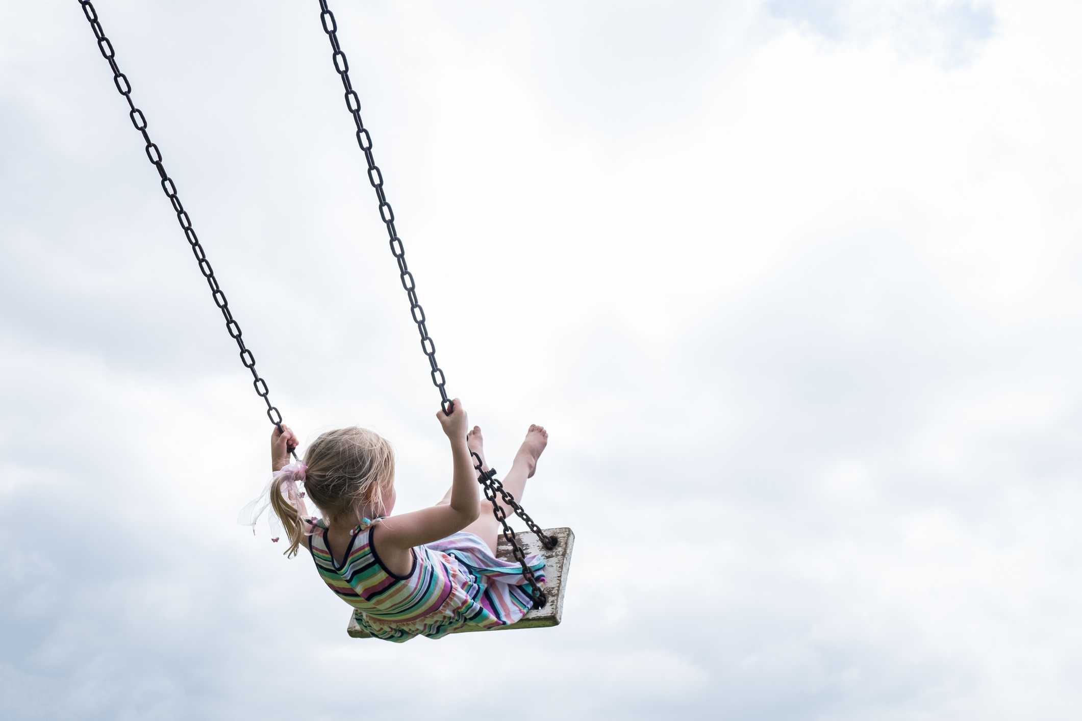 A child on a swing in a play area.