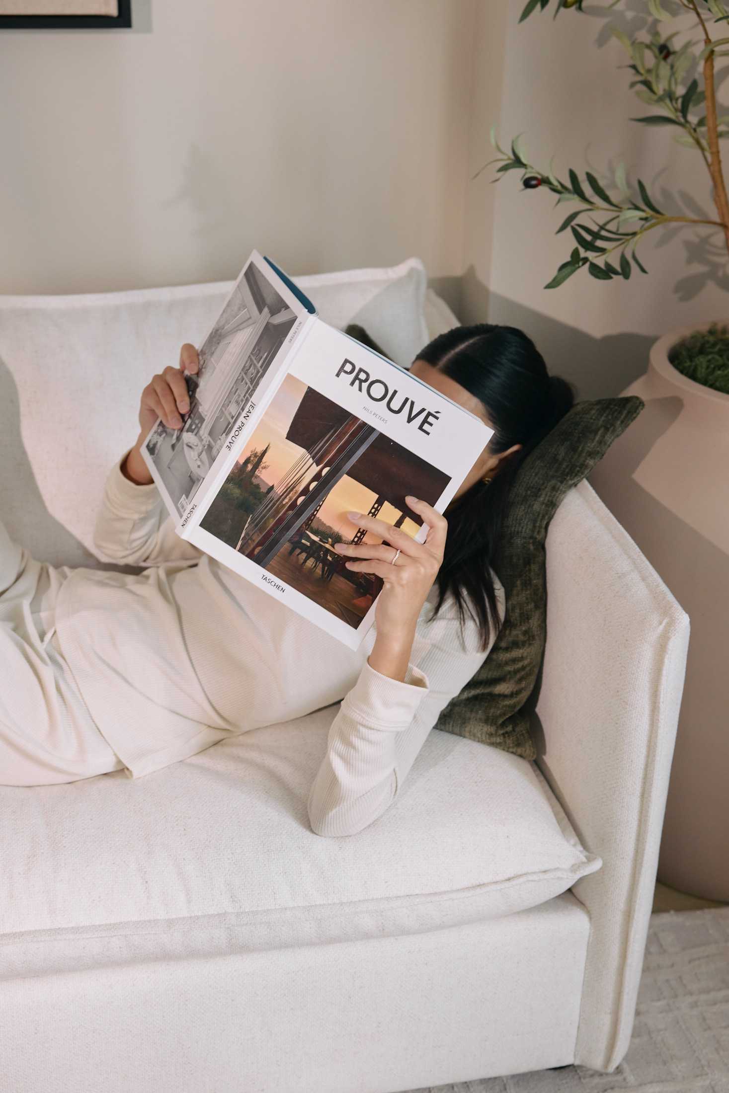 woman reading magazine on sofa